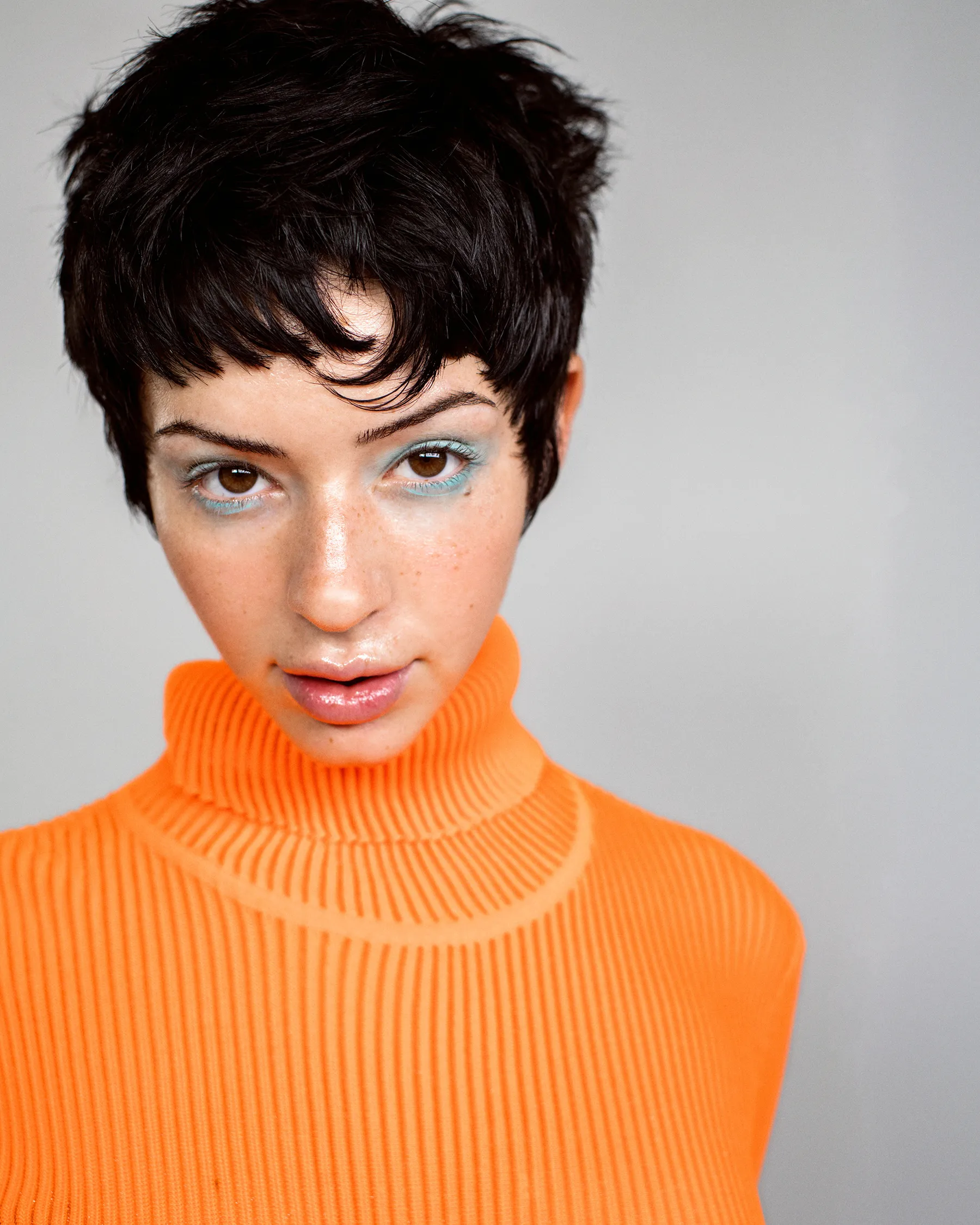 Model in an orange turtleneck with a short cut, from a Frankie campaign